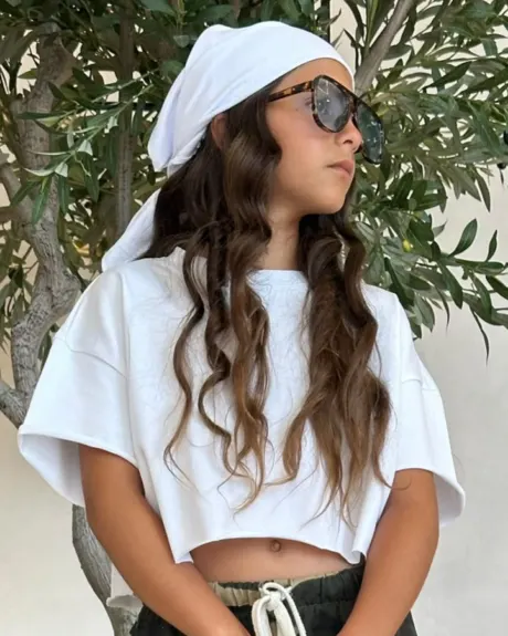 נערה בחולצה לבנה, בנדנה לבנה ומשקפי שמש